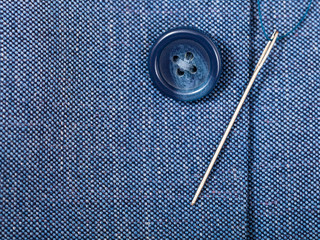 attaching of button to blue silk tissue by needle