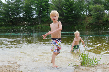 Two Young Children Swimming and Playing in Lake