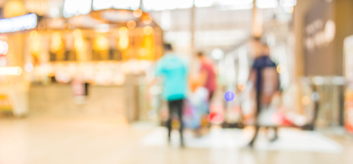 blurred image of shopping mall and people .