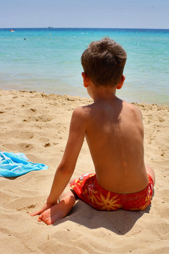BAMBINO DI SCHIENA IN SPIAGGIA