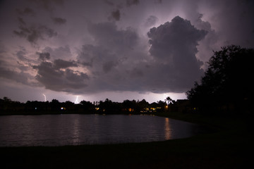 Heat lightning over a suburban neighborhood lake