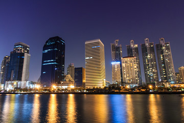 Fototapeta premium City Downtown w nocy z odbiciem budynku w rzece.