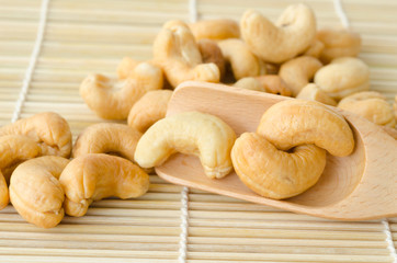 Close up cashew nuts in wooden spoon.