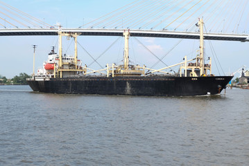 Cargo ship pass under the bridge