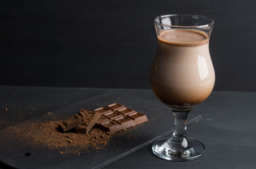 Glass of chocolate milkshake on the table