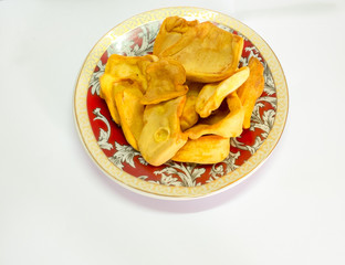 dried jackfruit chips in small plate on background.