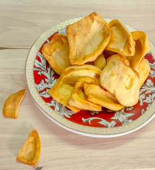 dried jackfruit chips in small plate on background.