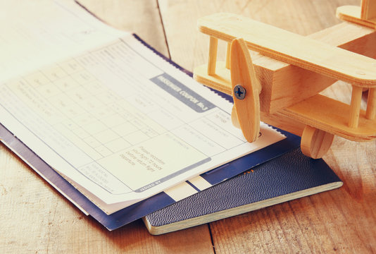 image of flying ticket wooden airplane and passport over wooden table