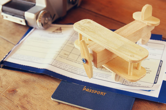 image of flying ticket wooden airplane and passport over wooden table