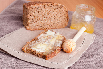 Fresh rye bread, butter and honey, close up, horizontal
