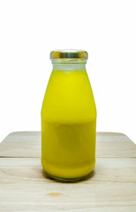 Fresh pumpkin juice in glass bottle on background