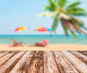 Image of blurred sea blue-sky coconut tree and colorful umbrella with coconut wooden plank under image