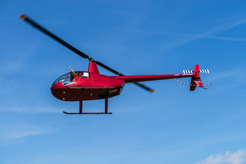 civilian helicopter flies past, pilot waving