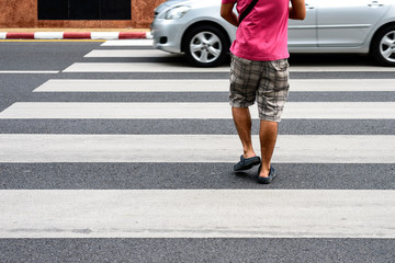 Man in pink shirt walking on crossway.