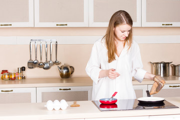 girl a white men's shirt in the kitchen preparing
