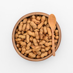 Roasted peanuts in wooden cup, top view isolated on white backgr