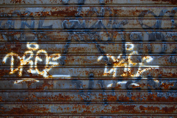 Rusty steel garage door with graffiti