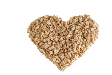 Heart shape made of textured soy protein granules, tilted angle, isolated on white background.