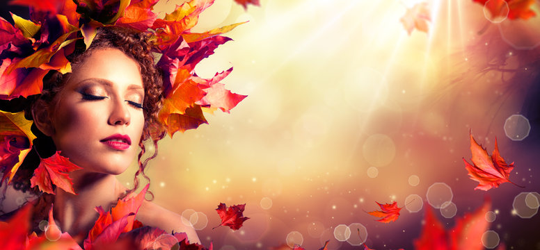 Autumn fantasy girl - Beauty fashion model with red leaves and sunlight
