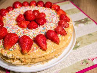 Honey cake with red strawberries