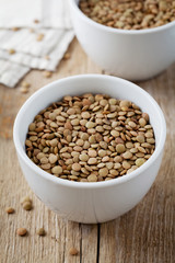 Bowl of dry lentils on a wooden background