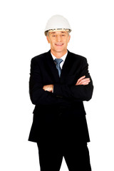 Smiling engineer with hard hat and folded arms