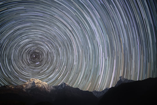 Spinning Universe.  Star trails over the snowy mountains. 