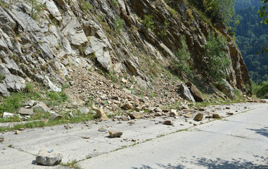 Rockfall in Carpathians where the road is covered with stones
