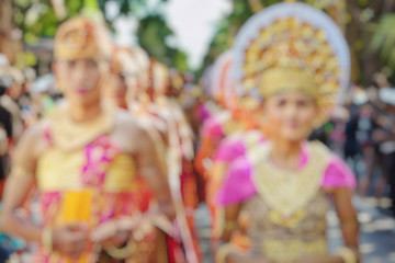 Wonderful  Indonesia blur background. Bali people in beautiful Balinese costumes and hats with traditional style face make-up on cultural parade.