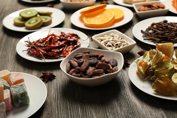 Different products on saucers on wooden table, closeup
