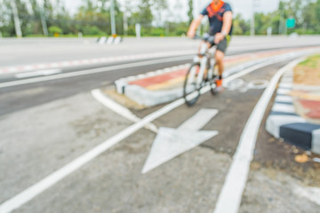 blur image of asphalt road and bike lane with sign