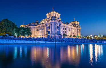 Illuminated Reichstag building with Spree river at dusk, Berlin, Germany