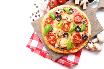 Tasty pizza with vegetables and basil on cutting board isolated on white