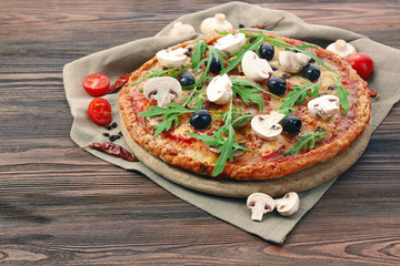 Tasty pizza with vegetables and arugula on table close up