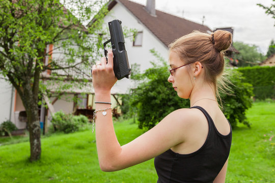 Teenager girl with gun at the ready