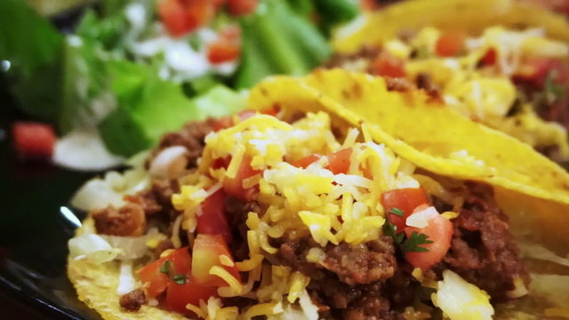 Soft Taco shells filled with mince meat, coriander and salsa on plate with salad