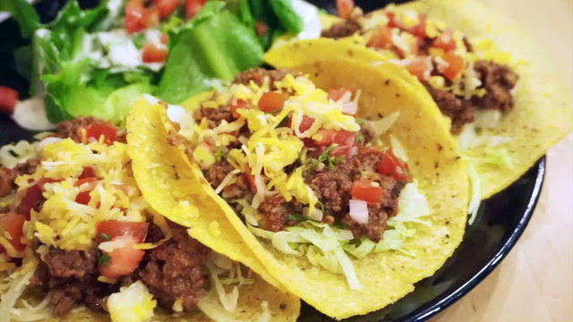 Soft Taco shells filled with mince meat, coriander and salsa on plate with salad