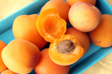 Ripe apricots on metal tray on table close up