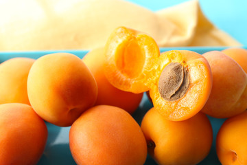 Ripe apricots on metal tray on table close up