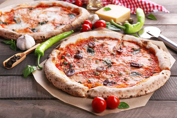 Delicious pizzas on wooden table, closeup