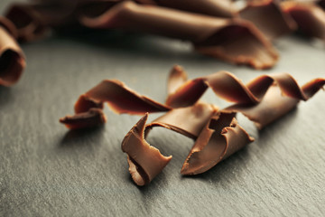 Chocolate curls on wooden table close up