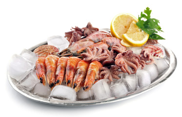Seafood with lemon and ice on metal tray isolated on white