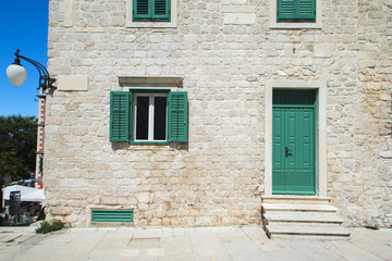 Fototapeta na wymiar Windows and doors on old traditional house in Sibenik, Croatia, facade details 