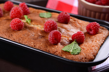 Fresh pie with raspberry in pan on wooden table, closeup