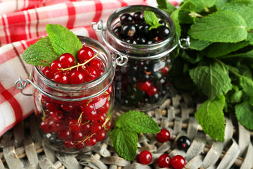 Ripe forest berries in glass jar  on wooden background