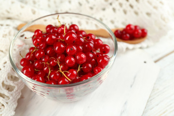 Ripe red currant  in glass bowl on light background
