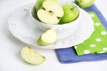 Green apples in saucer on table with napkins, closeup