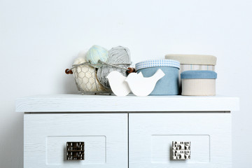 Textile boxes with decorative birds on wall background