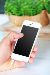 Music smartphone in male hand, on light background