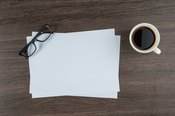 paper and glasses with cup of coffe office